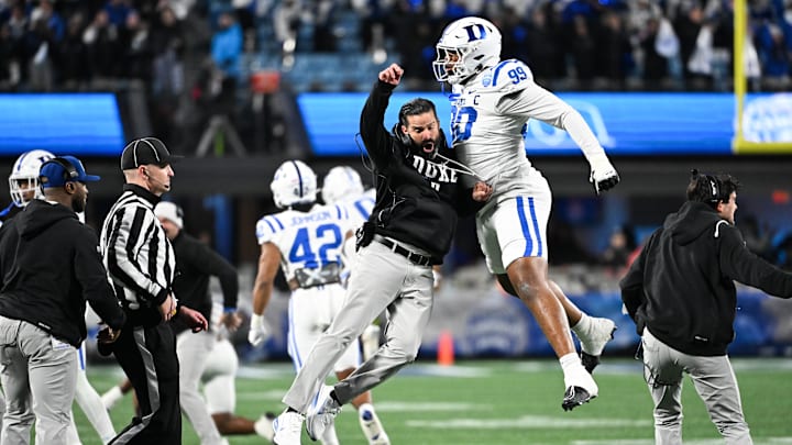 Dec 6, 2025; Charlotte, NC, USA; Duke Blue Devils head coach Manny Diaz reacts with defensive tackle Aaron Hall (99) in the first quarter against the Virginia Cavaliers during the 2025 ACC Championship game at Bank of America Stadium. Mandatory Credit: Bob Donnan-Imagn Images