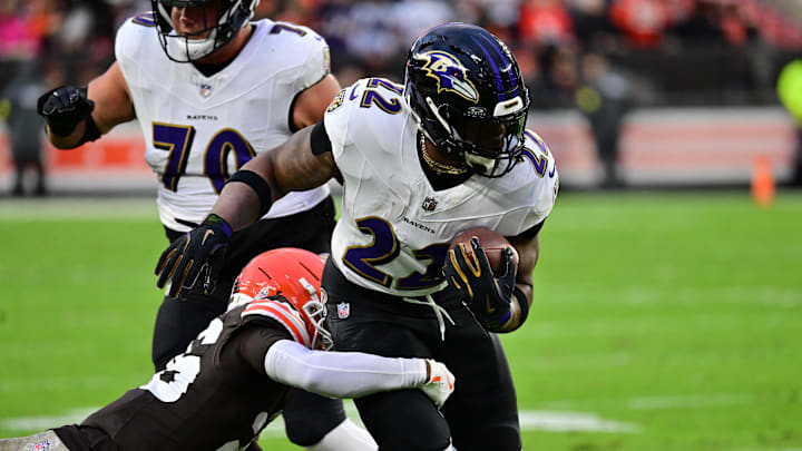 Nov 16, 2025; Cleveland, Ohio, USA; Baltimore Ravens running back Derrick Henry (22) runs for a gain past Cleveland Browns cornerback Myles Harden (26) during the first quarter at Huntington Bank Field. Mandatory Credit: Ken Blaze-Imagn Images