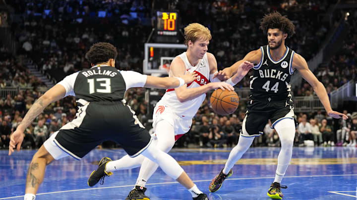 Nov 12, 2024; Milwaukee, Wisconsin, USA;  Toronto Raptors guard Gradey Dick (1) drives for the basket between Milwaukee Bucks guards Ryan Rollins (13) and Andre Jackson Jr. (44) during the second quarter at Fiserv Forum. Mandatory Credit: Jeff Hanisch-Imagn Images