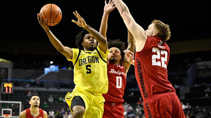 Feb 25, 2026; Eugene, Oregon, USA; Oregon Ducks guard Takai Simpkins (5) drives to the basket and is fouled by Wisconsin Badgers guard Braeden Carrington (0) during the first half at Matthew Knight Arena. Mandatory Credit: Craig Strobeck-Imagn Images Feb 25, 2026; Eugene, Oregon, USA; Oregon Ducks guard Takai Simpkins (5) drives to the basket and is fouled by Wisconsin Badgers guard Braeden Carrington (0) during the first half at Matthew Knight Arena. Mandatory Credit: Craig Strobeck-Imagn Images