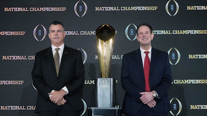 Miami Hurricanes coach Mario Cristobal (left) and Indiana Hoosiers coach Curt Cignetti pose with the national championship trophy during the CFP.