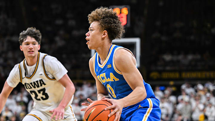 Jan 3, 2026; Iowa City, Iowa, USA; UCLA Bruins guard Trent Perry (0) controls the ball against Iowa Hawkeyes guard Isaia Howard (23) during the first half at Carver-Hawkeye Arena. Mandatory Credit: Jeffrey Becker-Imagn Images