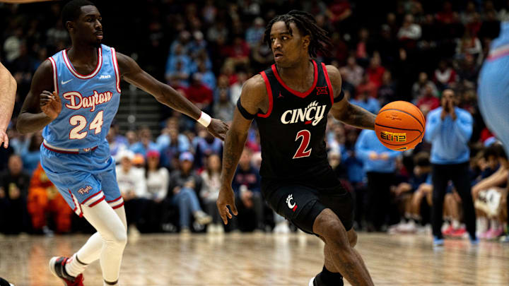 Cincinnati Bearcats guard Jizzle James (2) drives on Dayton Flyers guard Kobe Elvis (24) in the second half of the NCAA men's basketball game between the Dayton Flyers and Cincinnati Bearcats at Heritage Bank Center in Cincinnati on Saturday, Dec. 16, 2023. Cincinnati Bearcats guard Jizzle James (2) drives on Dayton Flyers guard Kobe Elvis (24) in the second half of the NCAA men's basketball game between the Dayton Flyers and Cincinnati Bearcats at Heritage Bank Center in Cincinnati on Saturday, Dec. 16, 2023.