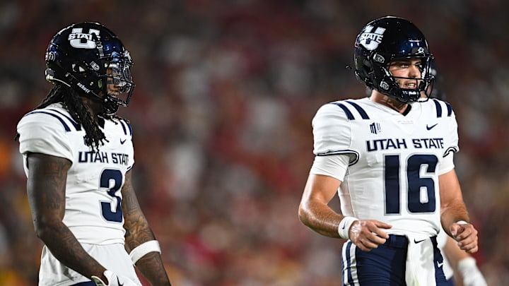 Sep 7, 2024; Los Angeles, California, USA; Utah State Aggies quarterback Bryson Barnes (16) and Utah State Aggies running back Rahsul Faison (3) react against the USC Trojans during the second quarter at United Airlines Field at Los Angeles Memorial Coliseum. Mandatory Credit: Jonathan Hui-Imagn Images