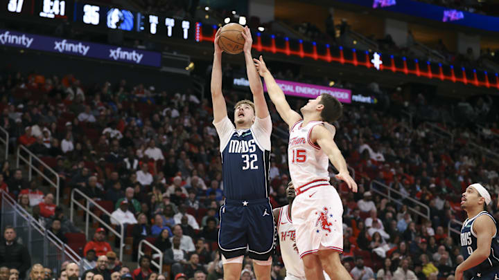 Jan 31, 2026; Houston, Texas, USA; Dallas Mavericks forward Cooper Flagg (32) grabs a rebound away from Houston Rockets guard Reed Sheppard (15) during the second quarter at Toyota Center. Mandatory Credit: Troy Taormina-Imagn Images