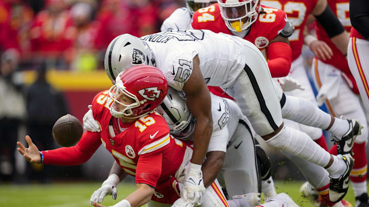 Dec 25, 2023; Kansas City, Missouri, USA; Kansas City Chiefs quarterback Patrick Mahomes (15) recovers his fumble as he is hit by Las Vegas Raiders defensive tackle Adam Butler (69) and defensive end Malcolm Koonce (51) during the first half at GEHA Field at Arrowhead Stadium. Mandatory Credit: Jay Biggerstaff-Imagn Images