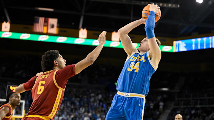 Feb 24, 2026; Los Angeles, California, USA; UCLA Bruins forward Tyler Bilodeau (34) shoots over Southern California Trojans forward Jacob Cofie (6) during the second half at Pauley Pavilion presented by Wescom Financial. Mandatory Credit: Robert Hanashiro-Imagn Images