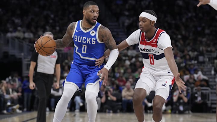 Nov 30, 2024; Milwaukee, Wisconsin, USA; Milwaukee Bucks guard Damian Lillard (0) brings the ball up the court against Washington Wizards guard Bilal Coulibaly (0) in the first half at Fiserv Forum. Mandatory Credit: Michael McLoone-Imagn Images