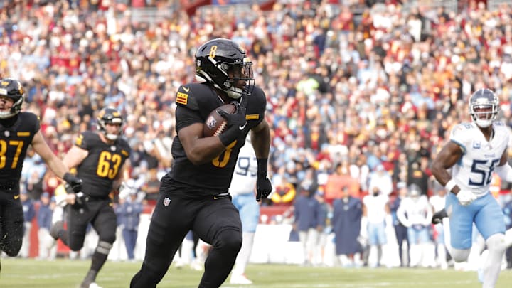 Dec 1, 2024; Landover, Maryland, USA; Washington Commanders running back Brian Robinson Jr. (8) carries the ball to score a touchdown against the Tennessee Titans during the first half at Northwest Stadium. Mandatory Credit: Amber Searls-Imagn Images