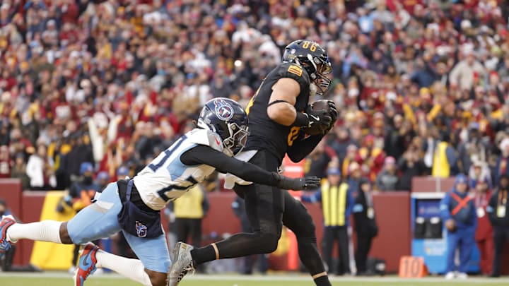 Dec 1, 2024; Landover, Maryland, USA; Washington Commanders tight end Zach Ertz (86) scores a touchdown past Tennessee Titans cornerback Jarvis Brownlee Jr. (29) during the second half at Northwest Stadium. Mandatory Credit: Amber Searls-Imagn Images