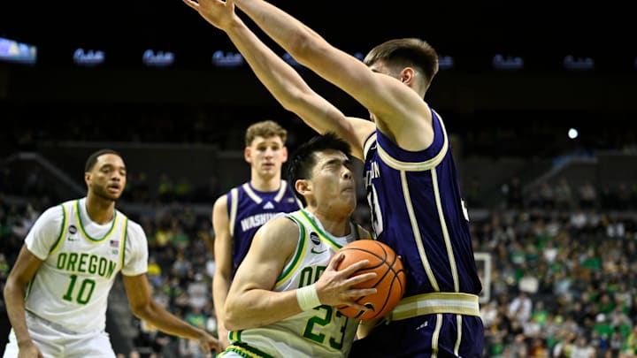 Oregon guard Wei Lin (23) gets a chestful of Nikola Dzepina of the Huskies in Eugene. 
