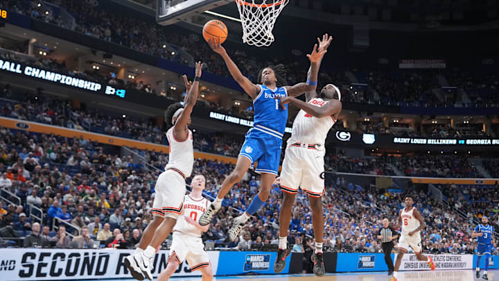 Mar 19, 2026; Buffalo, NY, USA; Saint Louis Billikens guard Quentin Jones (1) shoots the ball against Georgia Bulldogs guard Marcus Millender (4) and forward Dylan James (11) during the first half of a first round game of the men's 2026 NCAA Tournament at Keybank Center. Mandatory Credit: Gregory Fisher-Imagn Images