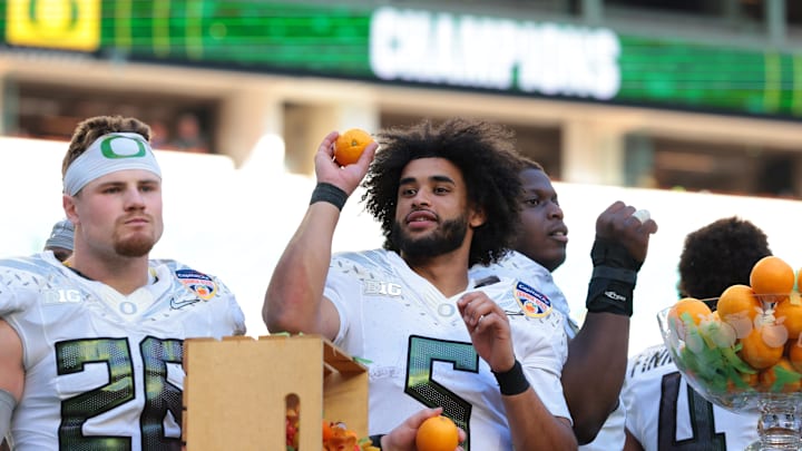 Jan 1, 2026; Miami Gardens, FL, USA; Oregon Ducks linebacker Devon Jackson (26) and quarterback Dante Moore (5) celebrate following the 2025 Orange Bowl and quarterfinal game of the College Football Playoff against the Texas Tech Red Raiders at Hard Rock Stadium. Mandatory Credit: Sam Navarro-Imagn Images