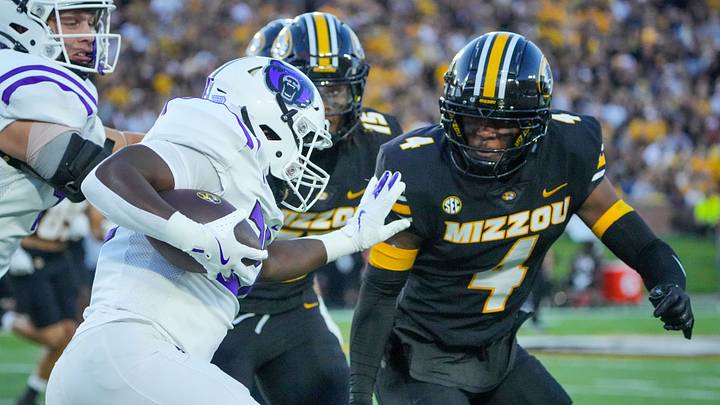 Aug 28, 2025; Columbia, Missouri, USA; Central Arkansas Bears running back Jalen Washington (20) runs the ball as Missouri Tigers safety Caleb Flagg (4) defends during the game at Faurot Field at Memorial Stadium. Mandatory Credit: Denny Medley-Imagn Images
