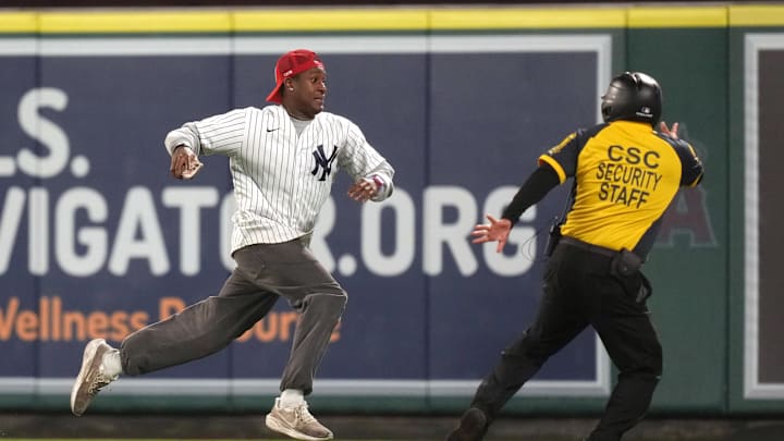 May 28, 2025; Anaheim, California, USA; A fan is pursued by CSC Event Security after running onto the field during the game between the New York Yankees and the Los Angeles Angels at Angel Stadium. Mandatory Credit: Kirby Lee-Imagn Images