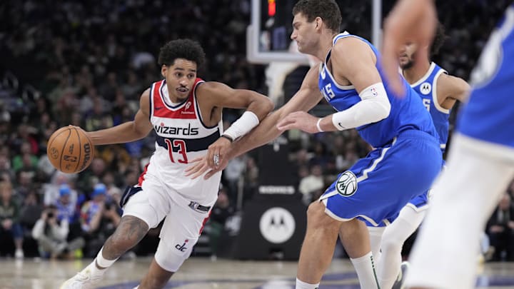 Nov 30, 2024; Milwaukee, Wisconsin, USA; Washington Wizards guard Jordan Poole (13) drives to the basket against Milwaukee Bucks center Brook Lopez (11) in the second half at Fiserv Forum. Mandatory Credit: Michael McLoone-Imagn Images