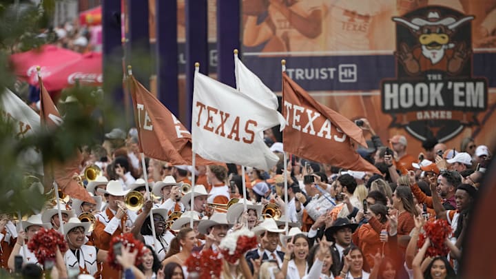 Austin, Texas, USA; Texas Longhorns flags are carried by the Marching Band during the Bevo Parade before a game against the Texas A&M Aggies at Darrell K Royal-Texas Memorial Stadium. 