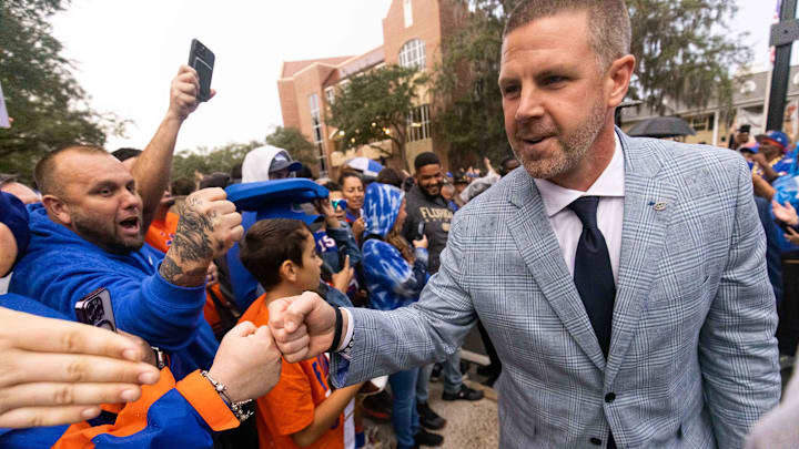 Florida Gators head coach Billy Napier gives fist bumps to fans during Gator Walk at Ben Hill