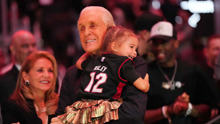 Oct 23, 2024; Miami, Florida, USA;  Miami Heat president Pat Riley holds his granddaughter following the Pat Riley Court dedication ceremony at halftime at Kaseya Center. Mandatory Credit: Jim Rassol-Imagn Images