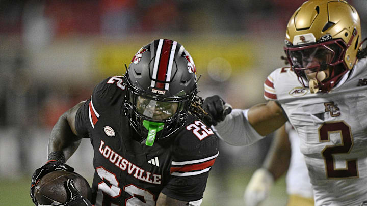 Oct 25, 2025; Louisville, Kentucky, USA;  Louisville Cardinals running back Keyjuan Brown (22) runs the ball for a touchdown against Boston College Eagles defensive back Kp Price (2) during the second half at L&N Federal Credit Union Stadium. Mandatory Credit: Jamie Rhodes-Imagn Images
