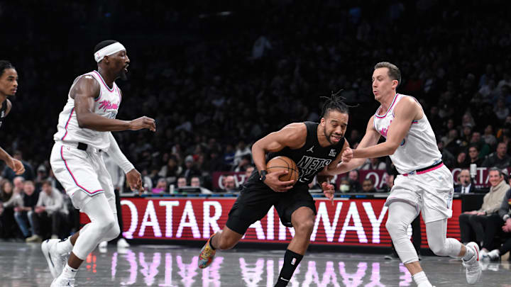 Jan 25, 2025; Brooklyn, New York, USA; Brooklyn Nets forward Tosan Evbuomwan (12) drives past Miami Heat forward Duncan Robinson (55) during the second half at Barclays Center. Mandatory Credit: John Jones-Imagn Images