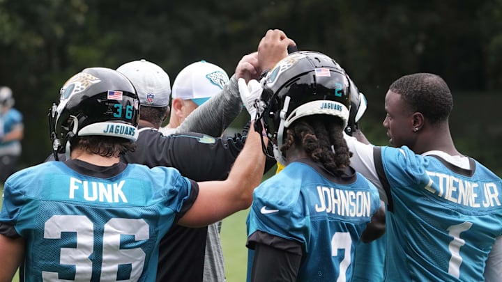 Oct 16, 2024; Watford, United Kingdom; Jacksonville Jaguars running backs Jake Funk (36), D'Ernest Johnson (2) and Travis Etienne Jr. huddle during practice at The Grove. Mandatory Credit: Kirby Lee-Imagn Images
