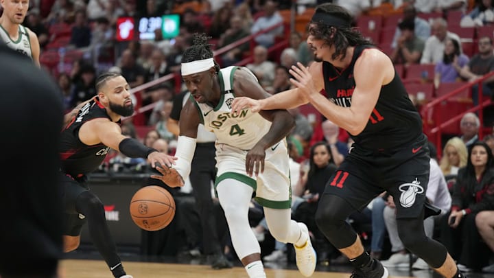 Feb 11, 2024; Miami, Florida, USA;  Boston Celtics guard Jrue Holiday (4) splits the defense of Miami Heat guard Jaime Jaquez Jr. (11) and Miami Heat forward Caleb Martin (16) during the first half at Kaseya Center. Mandatory Credit: Jim Rassol-USA TODAY Sports