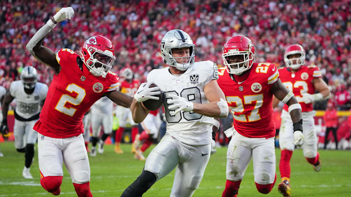 Nov 29, 2024; Kansas City, Missouri, USA; Las Vegas Raiders tight end Brock Bowers (89) scores a touchdown as Kansas City Chiefs cornerback Joshua Williams (2) and safety Chamarri Conner (27) chase during the second half at GEHA Field at Arrowhead Stadium. Mandatory Credit: Denny Medley-Imagn Images