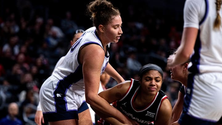 Kansas State Wildcats center Ayoka Lee (50) gets wrapped up with Cincinnati Bearcats forward Brianna Byars (10).