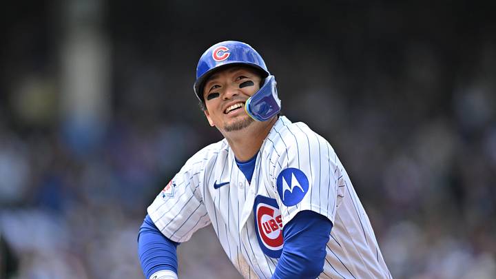 May 3, 2026; Chicago, Illinois, USA; Chicago Cubs right fielder Seiya Suzuki (27) looks up and smiles after leading off of first base and sliding back safely against the Arizona Diamondbacks during the third inning at Wrigley Field. Mandatory Credit: Patrick Gorski-Imagn Images