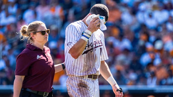 Jun 23, 2024; Omaha, NE, USA; Texas A&M Aggies left fielder Caden Sorrell (13) walks off with a trainer during the ninth inning against the Tennessee Volunteers at Charles Schwab Field Omaha. Mandatory Credit: Dylan Widger-Imagn Images