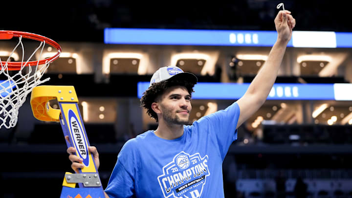 Mar 14, 2026; Charlotte, NC, USA; Duke Blue Devils forward Cameron Boozer (12) cuts down the net after defeating the Virginia Cavaliers in the men's ACC Conference Tournament Championship at Spectrum Center. Mandatory Credit: Bob Donnan-Imagn Images