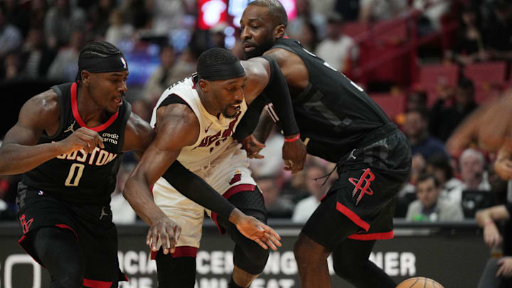 Jan 8, 2024; Miami, Florida, USA;  Miami Heat center Bam Adebayo (13) battles for a loos ball with Houston Rockets guard Aaron Holiday (0) and forward Jeff Green (32) during the second half at Kaseya Center. Mandatory Credit: Jim Rassol-Imagn Images