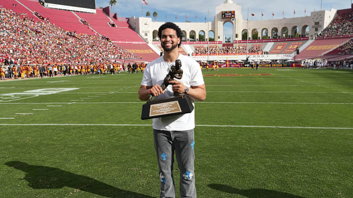 Nov 30, 2024; Los Angeles, California, USA; Chicago Bears and former Southern California Trojans quarterback Caleb Williams poses with Heisman Trophy at United Airlines Field at Los Angeles Memorial Coliseum. Mandatory Credit: Kirby Lee-Imagn Images