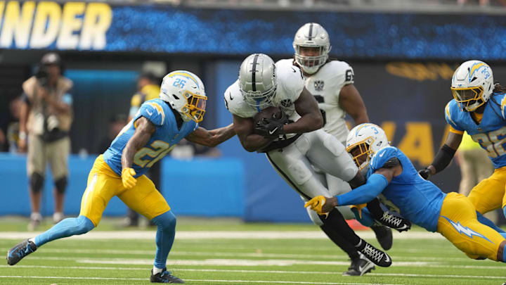 Sep 8, 2024; Inglewood, California, USA; Las Vegas Raiders running back Zamir White (3) is tackled by Los Angeles Chargers cornerback Asante Samuel Jr. (26) and safety Derwin James Jr. (3) in the second half at SoFi Stadium. Mandatory Credit: Kirby Lee-Imagn Images