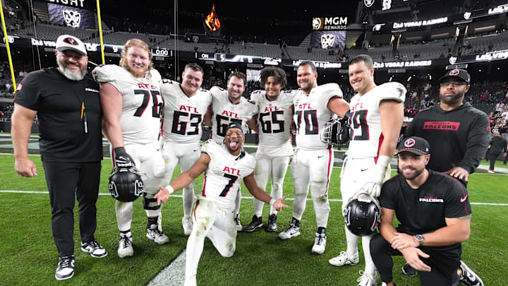 Dec 16, 2024; Paradise, Nevada, USA; Atlanta Falcons running back Bijan Robinson (7) poses with offensive tackle Kaleb McGary (76), guard Chris Lindstrom (63), center Drew Dalman (67), guard Matthew Bergeron (65), offensive tackle Jake Matthews (70) and tight end Charlie Woerner (89) after the game against the Las Vegas Raiders at Allegiant Stadium. Mandatory Credit: Kirby Lee-Imagn Images