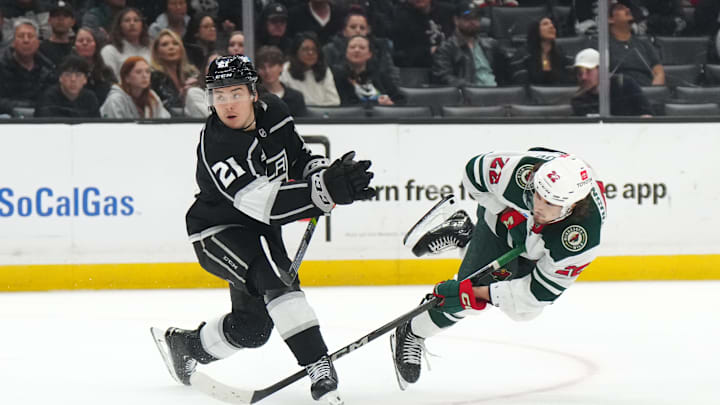 Apr 15, 2024; Los Angeles, California, USA; Minnesota Wild center Marat Khusnutdinov (22) shoots the puck against LA Kings defenseman Jordan Spence (21) in the third period at Crypto.com Arena. Mandatory Credit: Kirby Lee-Imagn Images