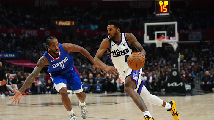 Dec 6, 2023; Los Angeles, California, USA; Sacramento Kings guard Malik Monk (0) dribbles the ball against LA Clippers forward Kawhi Leonard (2) in the second half at Crypto.com Arena. Mandatory Credit: Kirby Lee-Imagn Images