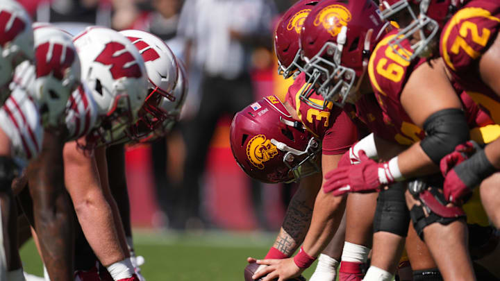 Sep 28, 2024; Los Angeles, California, USA; Southern California Trojans and Wisconsin Badgers helmets at the line of scrimmage in the second half at United Airlines Field at Los Angeles Memorial Coliseum.