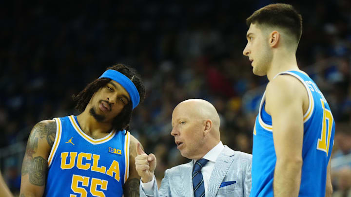 Mar 8, 2025; Los Angeles, California, USA; UCLA Bruins head coach Mick Cronin (center) talks with guard Skyy Clark (55) and guard Lazar Stefanovic (10) in the second half against the Southern California Trojans at Pauley Pavilion presented by Wescom. Mandatory Credit: Kirby Lee-Imagn Images