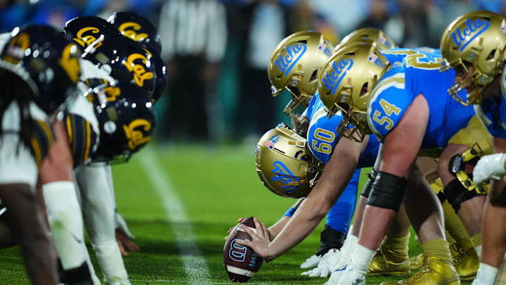 Nov 25, 2023; Pasadena, California, USA; Helmets at the line of scrimmage as UCLA Bruins long snapper Beau Gardner (60) snaps the ball against the California Golden Bears at the Rose Bowl. Mandatory Credit: Kirby Lee-Imagn Images