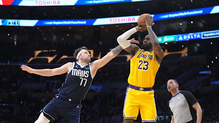 Jan 17, 2024; Los Angeles, California, USA; Los Angeles Lakers forward LeBron James (23) shoots the ball against Dallas Mavericks guard Luka Doncic (77) in the second half at Crypto.com Arena. Mandatory Credit: Kirby Lee-Imagn Images