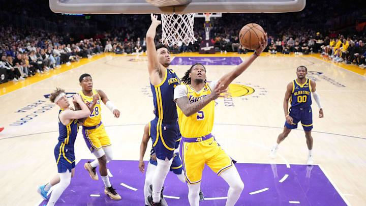 Apr 9, 2024; Los Angeles, California, USA; Los Angeles Lakers forward Cam Reddish (5) shoots the ball against Golden State Warriors forward Trayce Jackson-Davis (32) in the first half at Crypto.com Arena. Mandatory Credit: Kirby Lee-Imagn Images