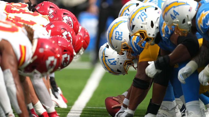 Sep 29, 2024; Inglewood, California, USA; Kansas City Chiefs and Los Angeles Chargers helmets at the line of scrimmage as Chargers long snapper Josh Harris (47) snaps the ball  at SoFi Stadium. Mandatory Credit: Kirby Lee-Imagn Images
