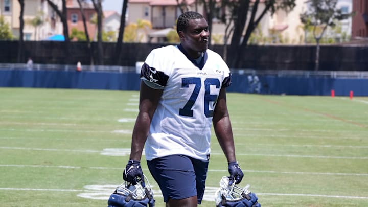 Dallas Cowboys offensive tackle Asim Richards carries helmets with Guardian helmet caps during training camp.
