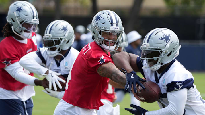 Dallas Cowboys quarterback Dak Prescott hands the ball off to running back Javonte Williams.