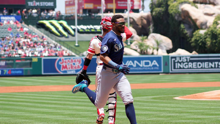 Seattle Mariners center fielder Julio Rodriguez (44) crosses home plate to score in the first inning as Los Angeles Angels catcher Logan O'Hoppe (14) watches at Angel Stadium on June 8. 
