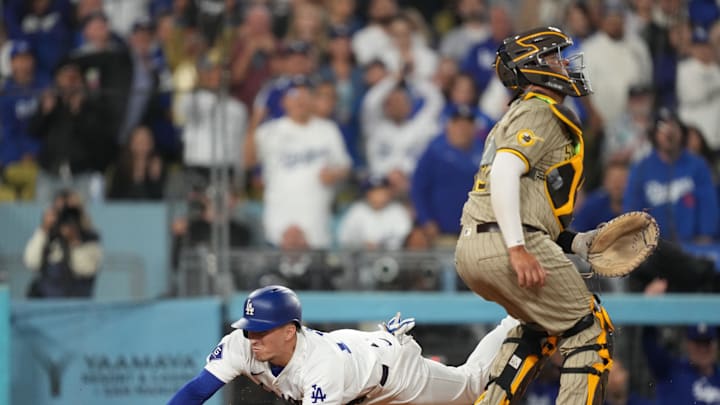 Sep 25, 2024; Los Angeles, California, USA;  Los Angeles Dodgers center fielder Tommy Edman (25) slides home to score a run while San Diego Padres catcher Elias Diaz (15) waits for a throw in the fourth inning at Dodger Stadium. Mandatory Credit: Kirby Lee-Imagn Images