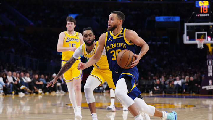 Apr 9, 2024; Los Angeles, California, USA; Golden State Warriors guard Stephen Curry (30) drives to the basket against Los Angeles Lakers guard D'Angelo Russell (1) in the second half at Crypto.com Arena. Mandatory Credit: Kirby Lee-Imagn Images