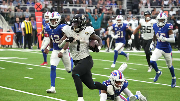 Oct 8, 2023; London United Kingdom; Jacksonville Jaguars running back Travis Etienne Jr. (1) is pursued by Buffalo Bills safety Micah Hyde (23) on a 35-yard touchdown run during the second half of an NFL International Series game at Tottenham Hotspur Stadium. Mandatory Credit: Kirby Lee-Imagn Images